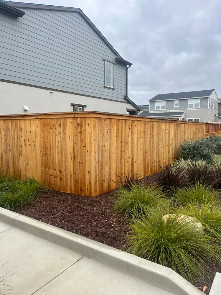 Gray-sided home and cedar fence line after exterior finishing work in Arroyo Grande, CA