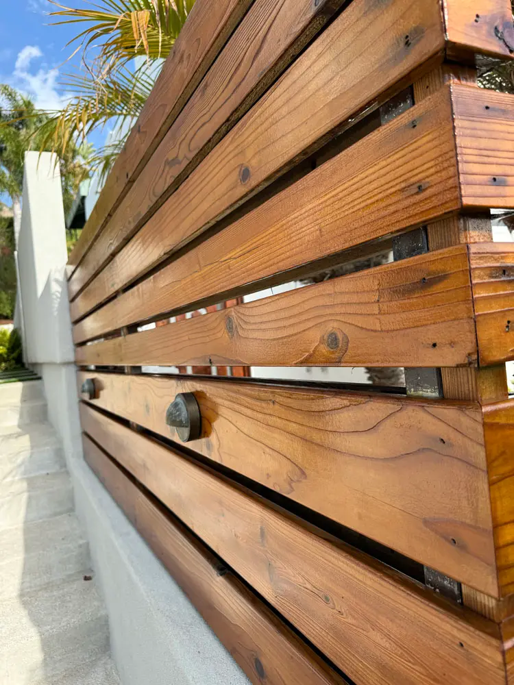 Stained horizontal slat wood screen and trim carpentry completed by Piñon Painting